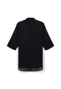Maglietta nera a maniche corte realizzata in tessuto leggero, caratterizzata da un design semplice con taglio dritto e un retro leggermente più lungo.