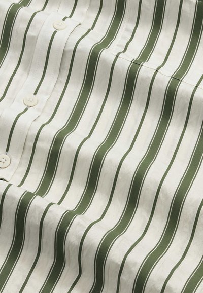 Tissu blanc à rayures verticales vert olive et boutons en plastique, montrant la texture et les détails de la couture des boutons.