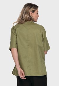 Olive green short-sleeve shirt with a relaxed fit, back seam detail, and a slightly curved hem, made from a lightweight fabric.