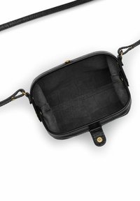 Liten svart lädercrossbodyväska med guldknäppning, öppen för att visa det ofodrade mockainredningen och justerbara remmar med guldhardware.