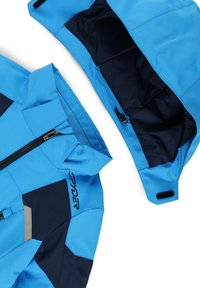Blaue Skijacke mit marineblauen Akzenten, ausgestattet mit einem Reißverschluss vorne, verstellbarem Kapuze und Klettverschlüssen an den Ärmelbündchen. Glatte Textur und modernes Design.
