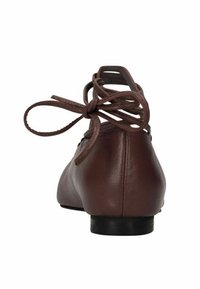 Bruine leren ballerina met een lage hak en een vetersluiting aan de achterkant. Gladde textuur en ronde neus.