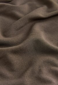 Brązowa tkanina o miękkiej, gładkiej fakturze z delikatnym żebrowanym wzorem. Materiał wydaje się lekki i miękko się układa.