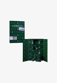 Calendrier de l'Avent vert avec le logo "essie", présentant des compartiments numérotés dans différentes nuances de vert. Motifs d'arbres décoratifs inclus.