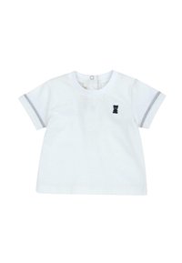 T-shirt blanc en coton à manches courtes, avec des accents rayés gris, un col rond, et une petite écusson noir en forme d'ours sur le devant.