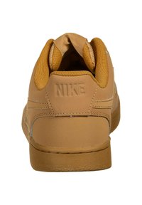 Sneaker Nike color marrone con esterno in pelle liscia, colletto in mesh testurizzato e logo cucito sul tallone. Suola piatta in gomma per una migliore aderenza.