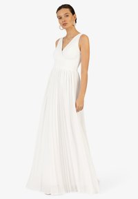 Hvid, ærmeløs maxikjole med V-hals, plisseret skørt og rynket bodice. Let stof giver et blødt og flydende udseende. Enkel design.
