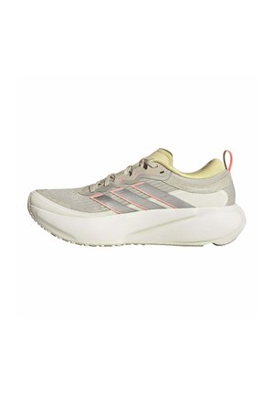 Chaussure de sport gris clair avec semelle blanche épaisse, dessus en mesh, accents roses, trois bandes latérales et languette au talon.