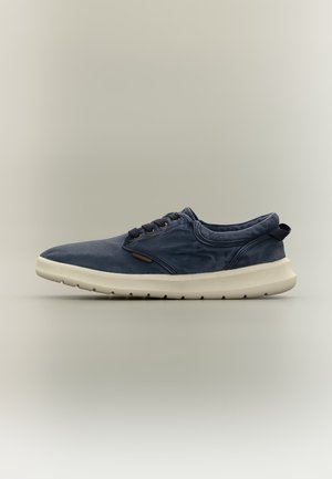 Scarpa da ginnastica casual blu navy con suola bianca, design basso, chiusura con lacci frontale e asola in tessuto sul tallone su sfondo neutro.