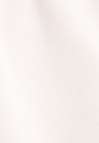 Lichtbeige stof met een gladde textuur en subtiel diagonaal patroon, gebruikt voor kleding of stoffering. Minimale zichtbare imperfecties.