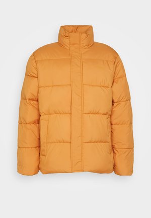 Oranje pufferjack met een hoge kraag, doorgestikte textuur en twee voorkleppen. Gemaakt van lichtgewicht, geïsoleerd materiaal.