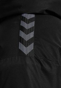 Czarna tkanina z pionowym paskiem odblaskowym z wzorem białych i czarnych jodełek przeszytym na środku.