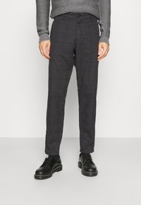 Kostkované kalhoty ve tmavě šedé barvě s nádechem hnědé. Slim fit, lehký materiál, s tlačítkovým zapínáním a bočními kapsami. Součástí jsou černé boty.