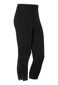 Svarta leggings med en kroppsnära design, kort längd och en skärdetalj i fållen med korsade accenter. Slät textur.
