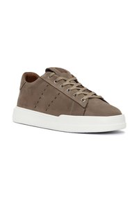 Zapatillas de ante marrón con cordones beige, suela de goma blanca, perforaciones laterales para ventilación y un logo en la lengüeta.