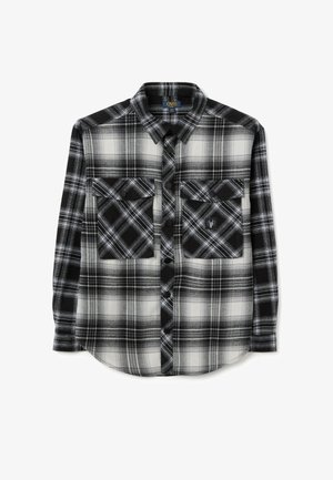 Camicia in flanella a quadri bianco e nero con maniche lunghe, due tasche sul petto, orlo arrotondato e chiusura a bottoni. Il tessuto presenta una texture morbida.