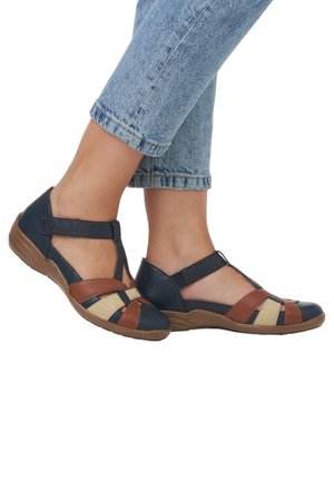 Chaussures décontractées bicolores en cuir bleu marine, marron et beige, avec des accents perforés et une semelle à petit wedge.