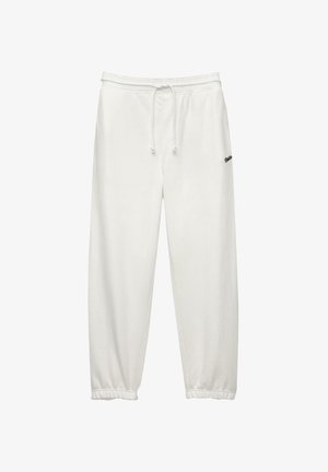 Pantaloni joggers bianchi in cotone con waistband elasticizzato, chiusura con cordino e caviglie a coste. Piccolo logo nero sul lato inferiore.