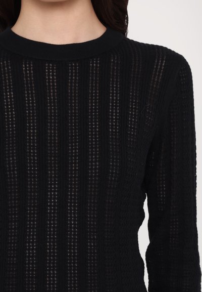 Sort strikket sweater med vertikale striber, ribbet tekstur og rund halsudskæring. Designet tillader lys at trænge gennem stoffet.