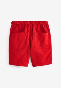 Shorts en coton rouge avec une taille élastique, deux poches arrière et un design épuré et simple. Aucun motif ni matériel visible.
