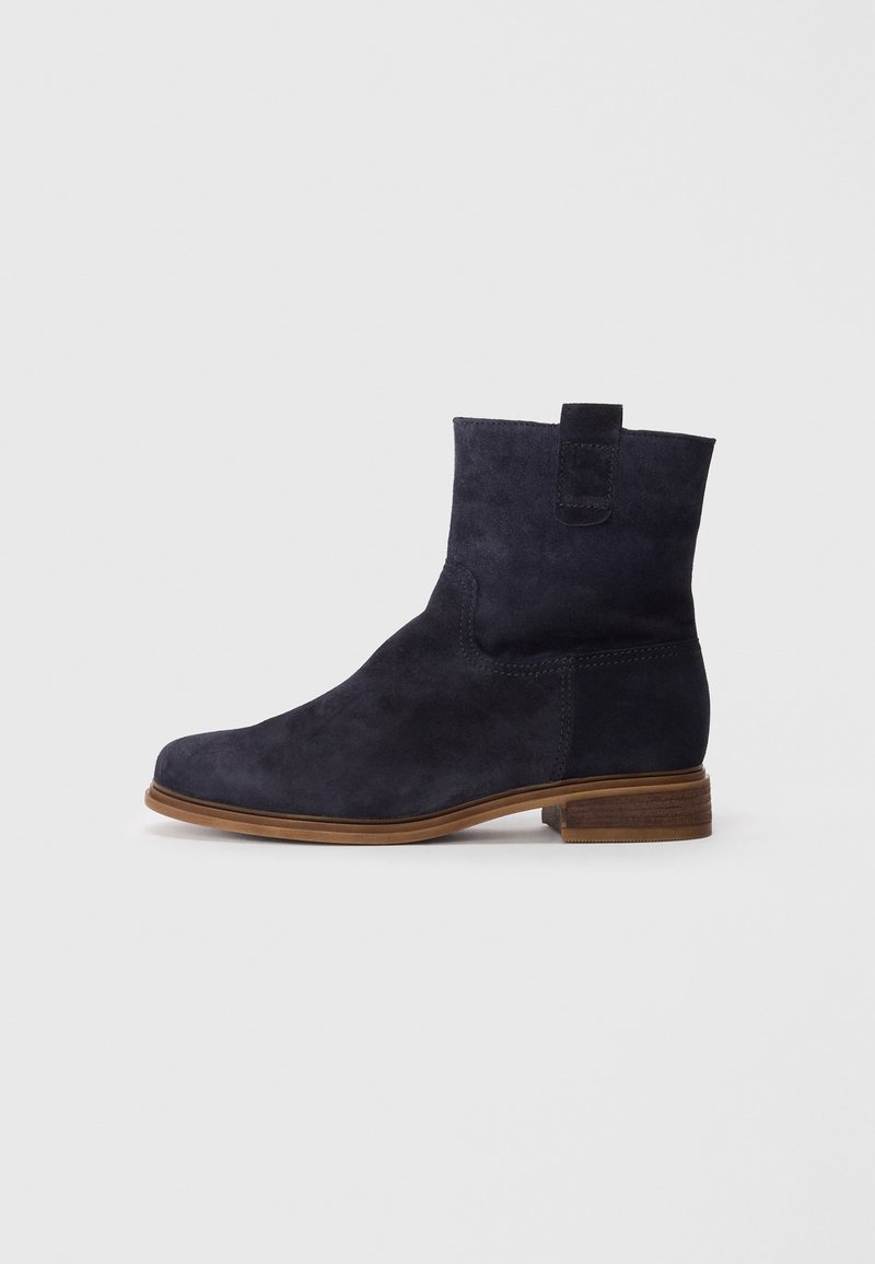 Botte cheville en daim bleu marine avec un bout arrondi, des coutures minimales, une languette au talon et un talon en bois empilé.