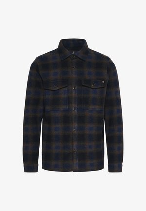 Chemise en flanelle à motif écossais bleu foncé et marron. Elle possède deux poches poitrine avec rabat et boutons-pression, des manches longues et un col.