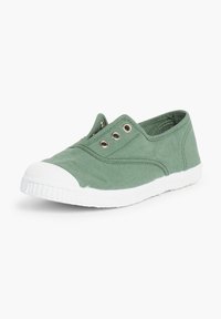 Bottines en toile verte avec un capuchon en caoutchouc blanc, présentant trois œillets en métal et une semelle texturée blanche.
