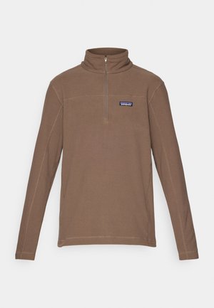 Bruine fleece trui met een ritssluiting bij de hals, lange mouwen en een aansluitende kraag. Voorzien van een klein logo patch op de linkerborst.