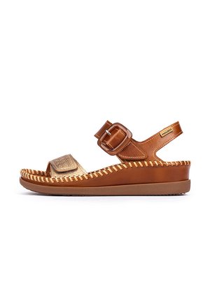 Bruine leren sandaal met een gouden sierriem, voorzien van een brede teenopening, verstelbare gesp en gedetailleerde stiksels langs de zool.