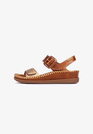 Bruine leren sandaal met een gouden sierriem, voorzien van een brede teenopening, verstelbare gesp en gedetailleerde stiksels langs de zool.