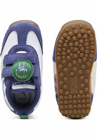 Vijolične semiš in bele sintetične otroške čevlje z Velcro zapiranjem, teksturiran gumijast podplat in okrogla zelena oznaka z risanim živaljo.