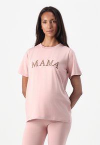 Pink cotton t-shirt featuring the word "MAMA" in brown print across the chest. Short sleeves, round neckline, and relaxed fit.