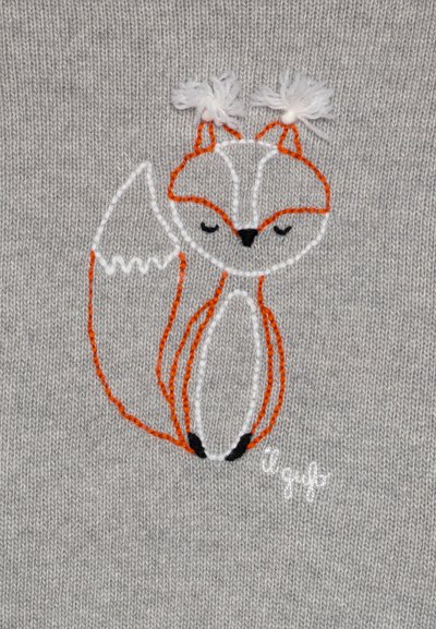 Design de renard brodé sur un fond en tricot gris, avec des points orange et blanc, et des pompons sur les oreilles.