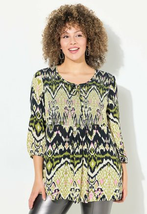 Bluse mit drei Viertelärmel, die ein grünes, schwarzes und pinkes Ikat-Muster zeigt, Rundhalsausschnitt mit einer Schleife und gerafftem Taillendetail.