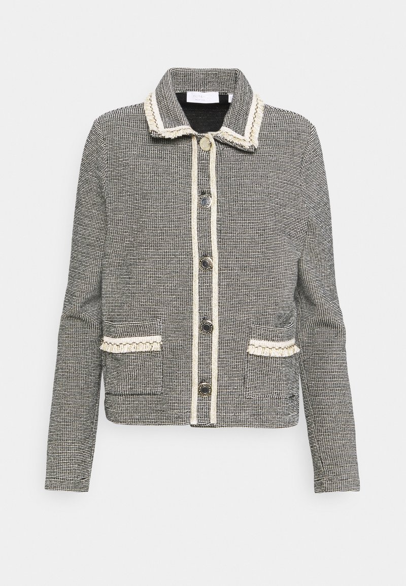 Veste à carreaux noir et blanc avec un col, poches avant, bordure crème contrastante et cinq boutons de fermeture. Texture tissée lisse.