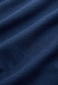 Tmavomodrá tkanina s hladkou textúrou, zobrazujúca jemné záhyby a jemný lesk. Väzba je pevne upletená bez viditeľných vzorov.