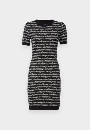 Schwarzes Kurzarmkleid mit sich wiederholendem weißen "Tommy Jeans"-Textmuster, geripptem Rundhalsausschnitt und tailliertem Schnitt. Strickstofftextur.