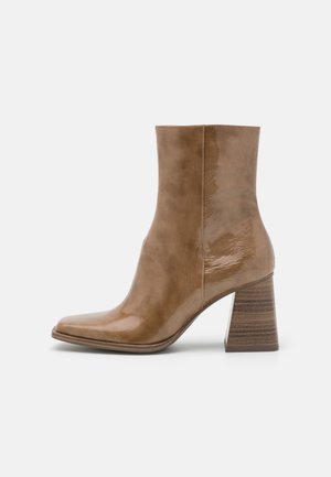 Bottines en cuir verni marron avec un bout pointu, un talon bloc texturé et une finition lisse. Présente une silhouette élégante et un design sans couture.