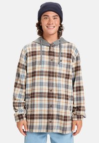 Camisa de cuadros en tonos de marrón, crema y azul con capucha gris. Presenta botones, mangas largas y un corte relajado.