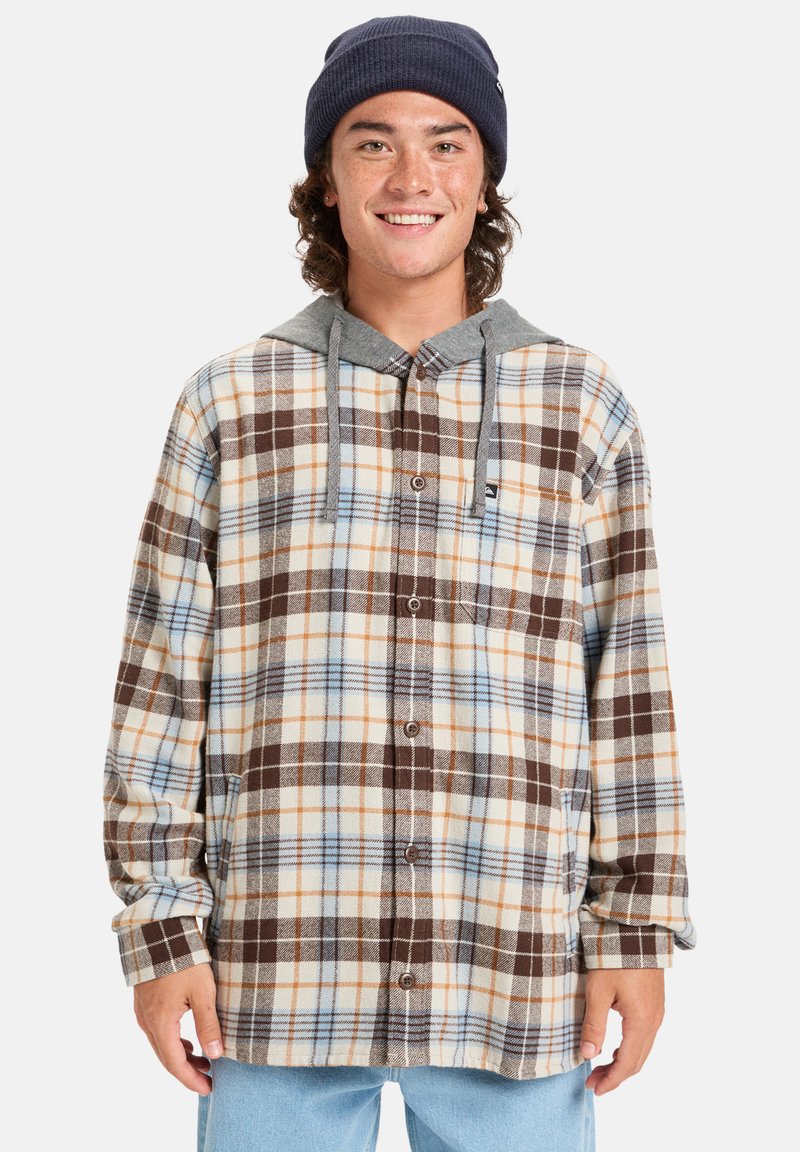 Camisa de cuadros en tonos de marrón, crema y azul con capucha gris. Presenta botones, mangas largas y un corte relajado.
