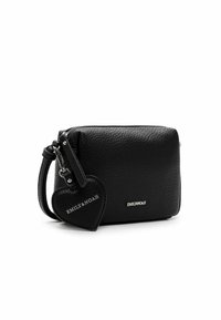 Schwarze Lederhandtasche mit strukturiertem Oberflächen, Reißverschluss und abnehmbarem herzförmigem Anhänger. Verfügt über ein silbernes Logo auf der Vorderseite.