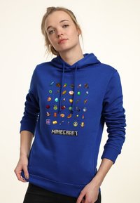 Sudadera azul con un diseño pixelado que presenta varios motivos de Minecraft. Tejido suave con capucha ajustable y puños y dobladillo acanalados.