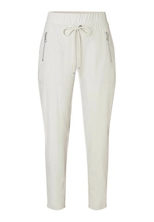 Light beige jogger pants with an elastic waistband, drawstring, and two side zip pockets. Smooth fabric with a tapered leg design.