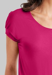 Fuchsia korte mouwen top met een ronde halslijn. Gladde, rekbare stof met een lichte glans. Casual ontwerp, geen patronen of versieringen.