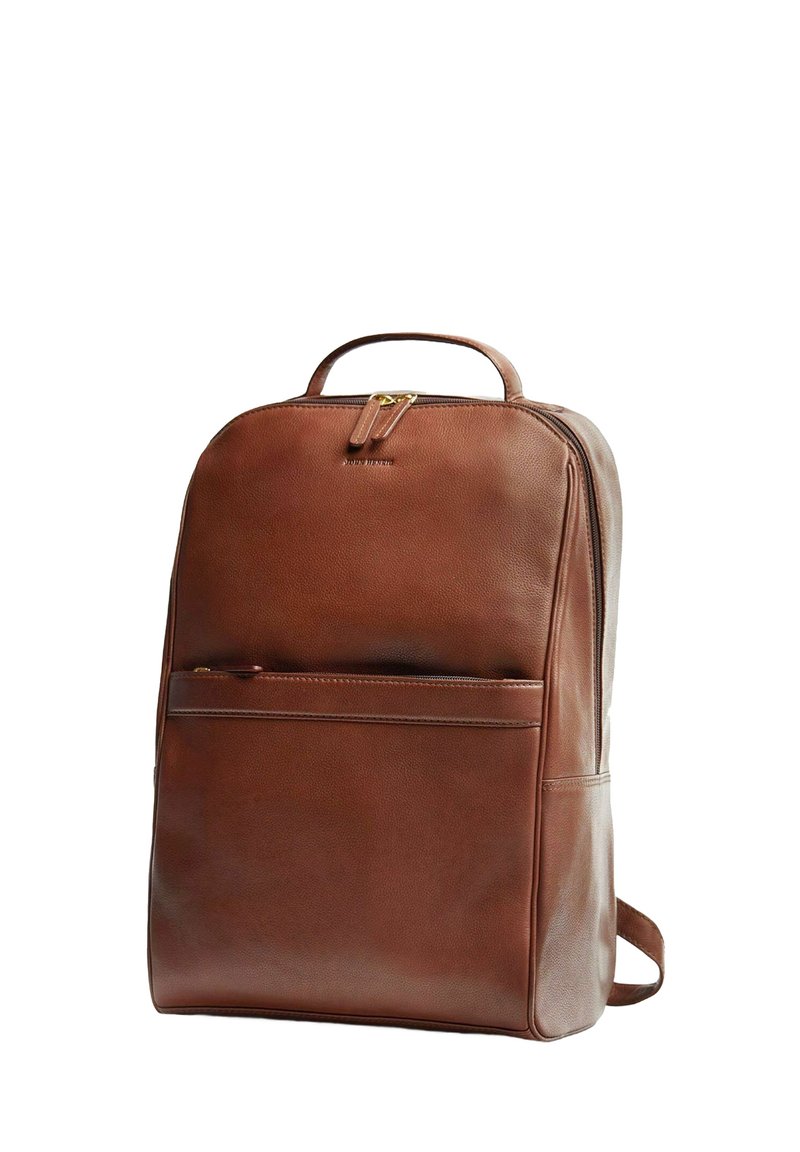 Ruskea nahkainen reppu, jossa on tyylikäs muotoilu. Siinä on etutasku, kantokahva ja säädettävät olkahihnat. Kultaiset metalliosat.