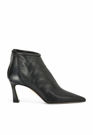 Zwarte geperforeerde leren enkellaarzen met een spitse neus, slanke stilettohak en ritssluiting aan de achterkant. Textuur oppervlakontwerp.