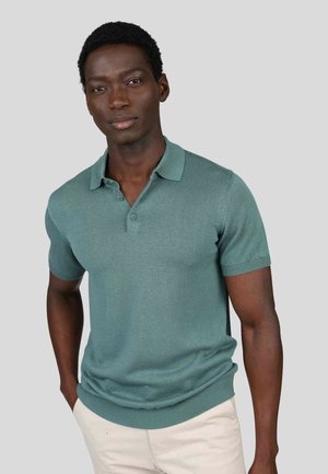 Polo à manches courtes en teal, en tissu tricoté avec un col et des poignets côtelés, doté d'une patte de boutonnage à deux boutons.