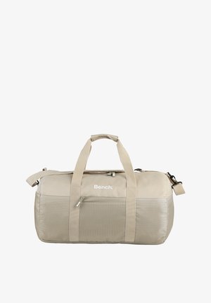 Bolsa de deporte beige hecha de tela resistente, con tapa con cremallera, dos asas robustas y un bolsillo lateral con acentos texturizados.