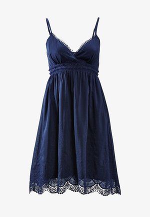 Námořnická modrá bezramenná šaty s výstřihem do V, krajkovým lemem, výšivkou a splývavou sukní. Disponuje krajkovým lemem ve tvaru vlny.