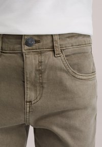 Camel-farvede denimjeans med subtil tekstur, der har knapgylp, lommer foran og bagpå samt kontrastsyning. Klassisk pasform.